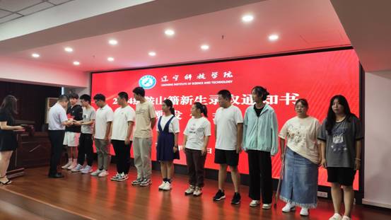 图为 pg娱乐电子游戏官网入口副校长葛会奇为鞍山级籍学生颁发录取通知书
