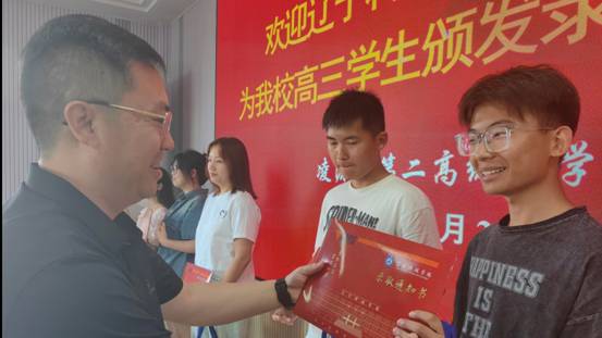 图为 pg娱乐电子游戏官网入口党委副书记宋明凯为凌源第二高级中学学生颁发录取通知书